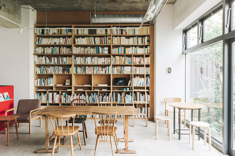カンケイマルラボ奥のカフェスペース。アート系を中心とした蔵書が並ぶ本棚も壮観。